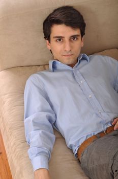 attractive young man lying and relaxing on the couch