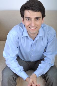 smiling attractive young man sitting on the couch