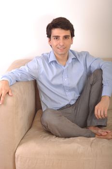 smiling attractive young man sitting on the couch