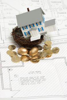 A home investment concept with gold coins, eggs and a model house in a nest.