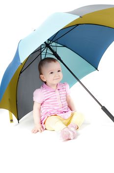 Shot of cute baby girl sitting uner umbrella