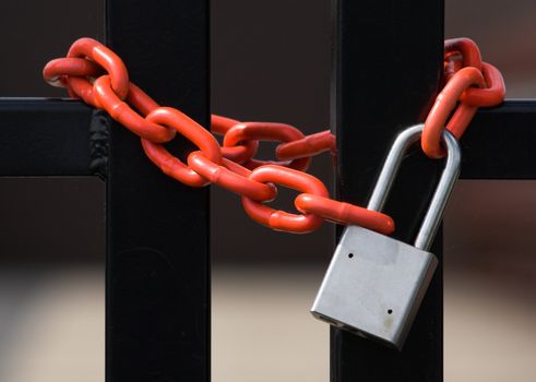 A chain and padlock around a fence