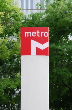 metropolitan sign with green trees in the background 