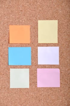 many colorful sticky notes on a bulletin board