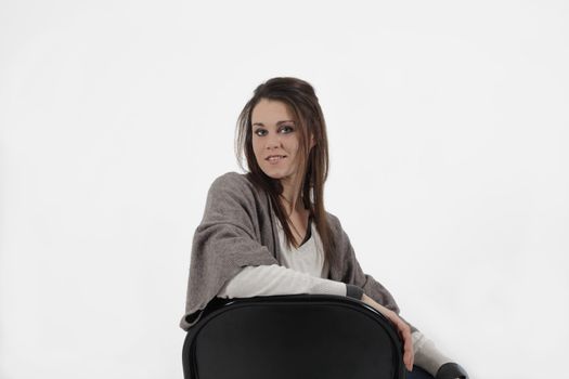 Young woman in studio with metalic chair, looking at the camera