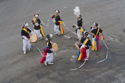 The group of dancers are dancing in the road in South Korea.