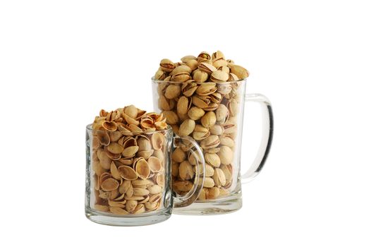 Two glass beer mugs filled with salted pistachios and nutshells