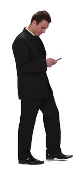 Image of a young businessman walking and checking his mobile phone,isolated against a white background.