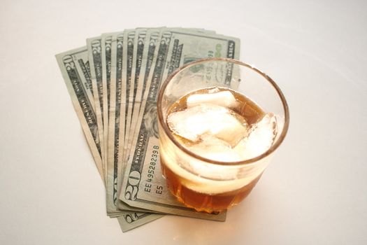 glass of alcohol with dollar bills