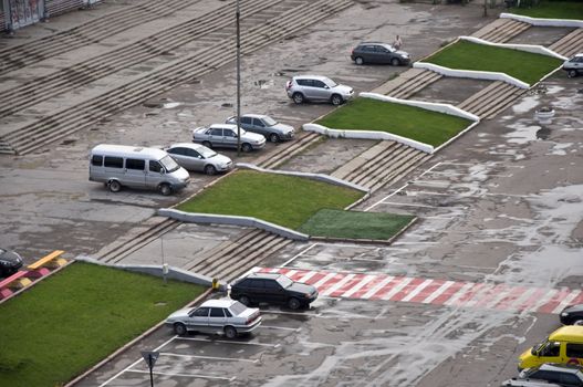 Parked cars in the town square and landscaping. Picture taken from a height.