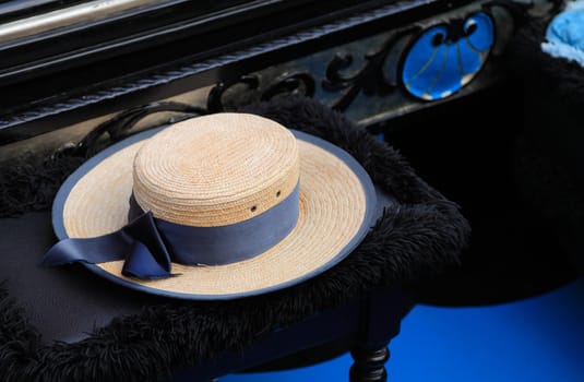 Image of a hat of a gondolier on a specific chair in a gondola.