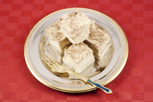 Delicious Halva served in silver-golden dish on red table