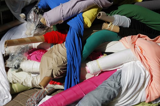 Eastern textile street market - heap of fabric rolls 