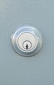 A lock in the grayish metal door