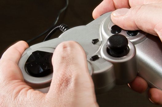 hands holding silver gamepad of video game