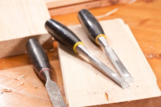 tools series: steel chisel on wooden plank with shaving