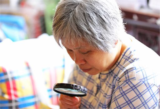 senior woman using magnifier