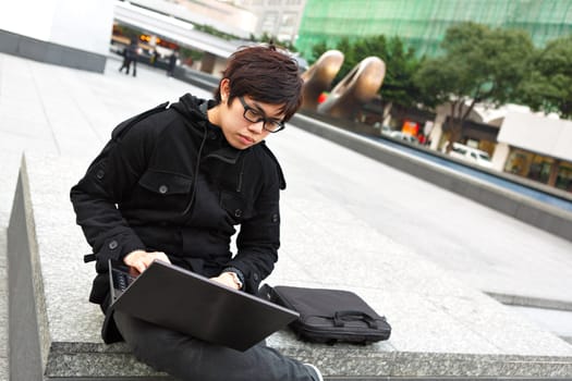 asian man using computer outdoor