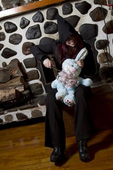 Evil young women killing a blue plush bunny