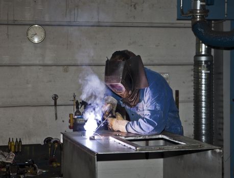 Welding operator in an auto repair shop