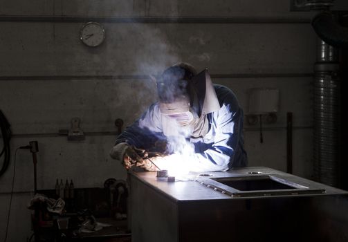Welding operator in an auto repair shop