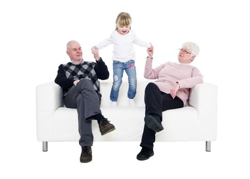 Little Girl with her grandparents in a sofa isolated on white background