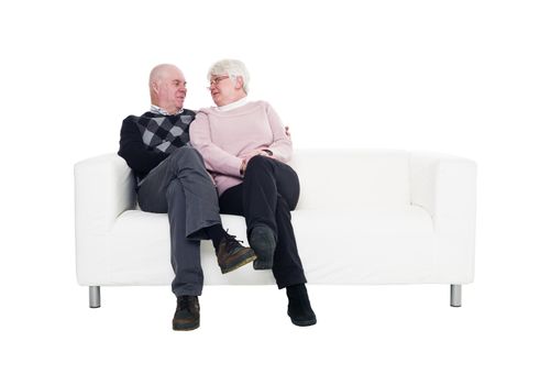 Older couple in a sofa isolated on white background