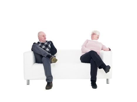 Older couple in a sofa isolated on white background