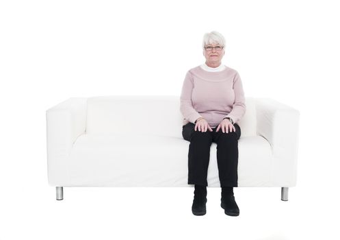 Older woman in a sofa isolated on white background