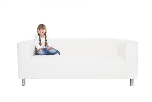 Young girl in a sofa isolated on white background