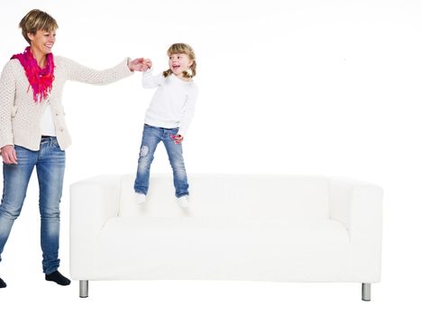 Young girl with her mother in a sofa isolated on white background