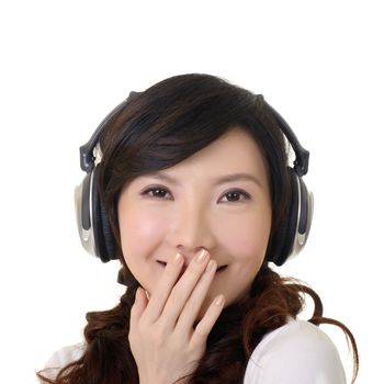 Smiling Asian woman put hand on lips and listen music with headphone.
