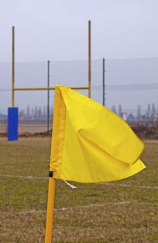 Yellow banner in a rugby field, with poles in the background