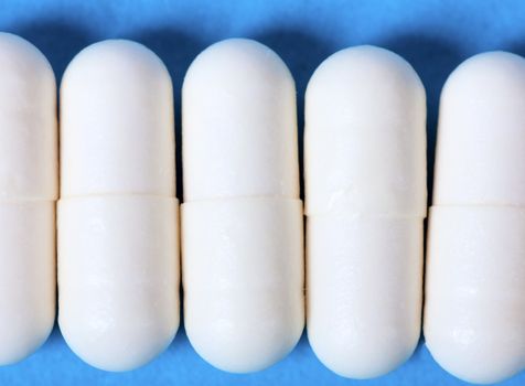 Macro view of white pills on a blue background