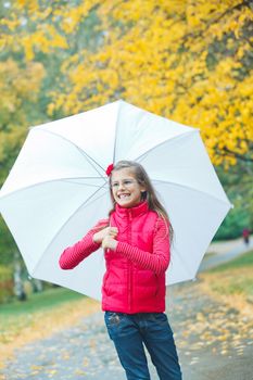 Cute girl with white umbrella walking in the autumn park