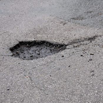 pothole road damage or pot hole concept with street