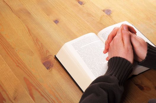 praying hands and book showing christian religion concept