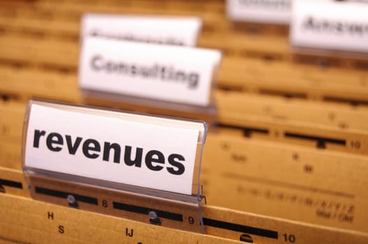 revenue or revenues word on business office folder showing financial success