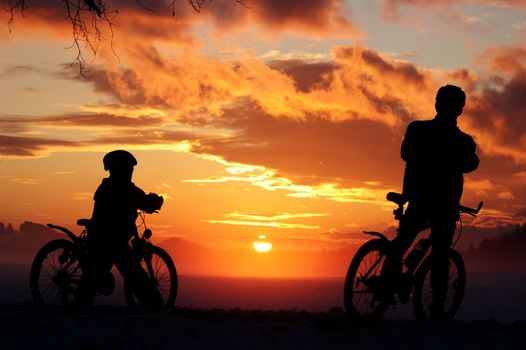 Father and son riding through misty sunset