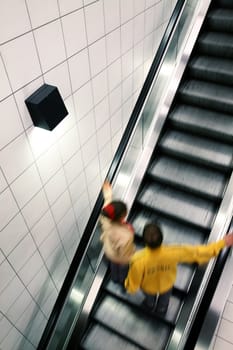 Couple moving on escalator, with motion blur