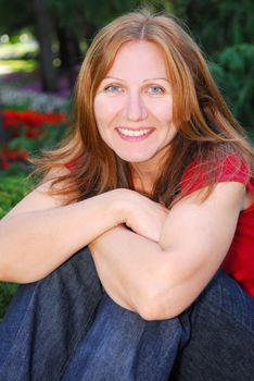 Portrait of smiling attractive mature woman relaxing in summer park