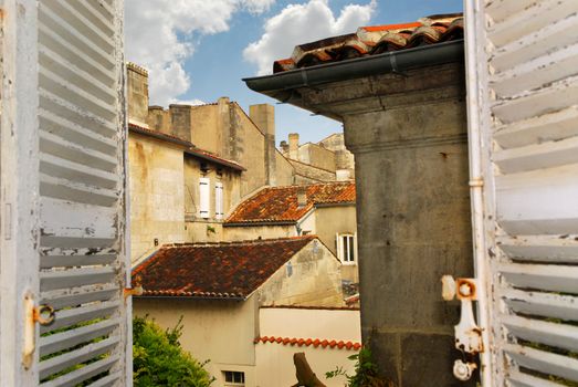 View from an open window with shutters in town of Cognac, France