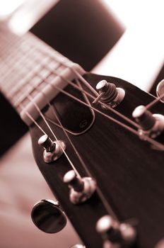 Headstock and tuners of an acoustic guitar close up 