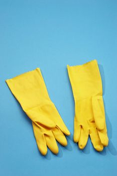 yellow rubber gloves on the blue background