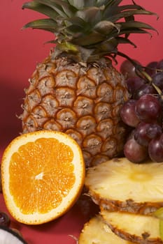 still life: sliced ripe exotic fruit over red background
