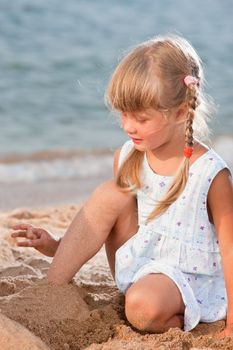 people series: little girl on sea beach are play the sandy game