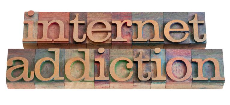internet addiction phrase in vintage wooden letterpress printing blocks, stained by color inks, isolated on white