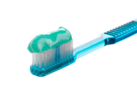 A blue toothbrush holding sparkly mint toothpaste.  Closeup with shallow dof.