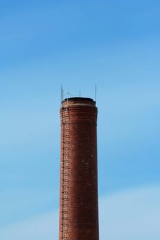 A Red brick smokestack with blue sky