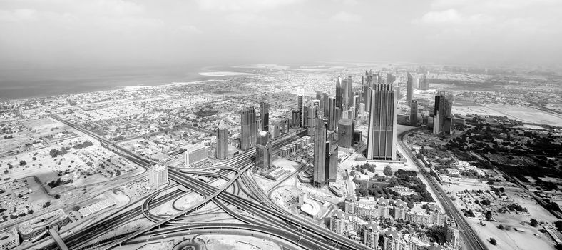 Black and white panorama view over skyscrapers and roads in Dubai city.